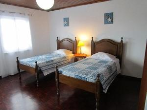 1 dormitorio con 2 camas, mesa y ventana en Casa do Cruzeiro, en Lagoa