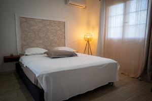 a bedroom with a large white bed with a window at Le Cocon de Bagatelle in Sainte-Suzanne