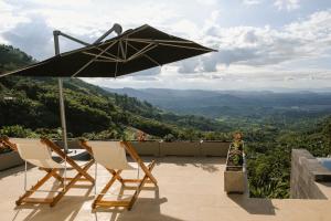 two chairs and an umbrella on a patio with a view at Casa Margarita Loft in Buenavista