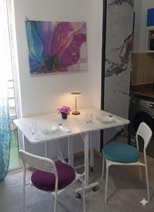 a white table with two chairs and a table with a purple seat at Wavesong Whispers flat where you can enjoy seaview with the best price and enjoy speedy wifi for forigners only ممنوع المصريين in Hurghada