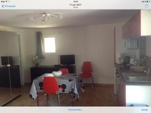 a kitchen with a table and red chairs in a room at A Stalla in Piana