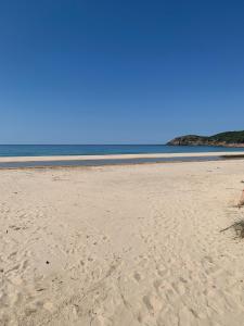 a sandy beach with the ocean in the background at A Stalla in Piana +10 photos