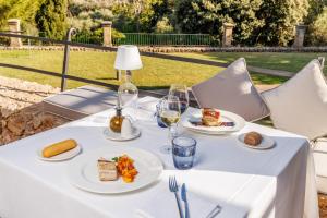 a table with plates of food and glasses of wine at Hotel Llenaire in Port de Pollensa +76 photos