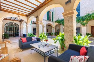 an outdoor patio with couches and a table at Hotel Llenaire in Port de Pollensa