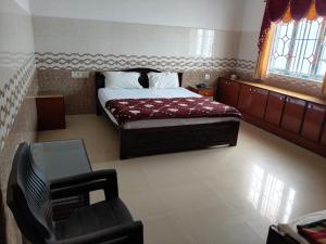 a bedroom with a bed and a chair in it at R R Paradaise in Pūtalapattu