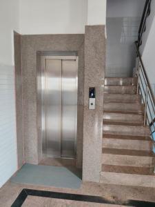 a metal elevator in a building with stairs at R R Paradaise in Pūtalapattu