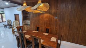 a dining room with a wooden table and chairs at The Ocean Breeze Villa in Tangalle