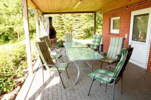a patio with a table and chairs on a house at Ferienhaus Ostsee in Rabenkirchen-Faulück