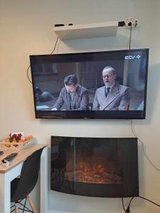 a flat screen tv hanging above a fireplace at A 3-bedroom apartment on the second floor in Tallinn