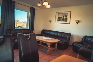 a waiting room with leather couches and a table at Ferienhaus Ostsee in Rabenkirchen-Faulück +12 photos