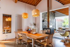 a dining room with a table and chairs and a fireplace at Casa da Arvore Chale by Green Vacations in Calhetas