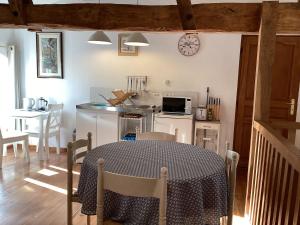 a kitchen and dining room with a table and a clock at La Grange in Yviers +8 photos