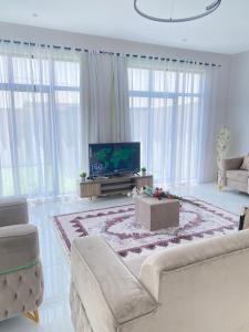 a living room with a couch and a tv at شاليه غيوم الفندقية in Taif