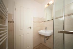 a white bathroom with a sink and a mirror at Schleiblick App 5 in Rabenkirchen-Faulück