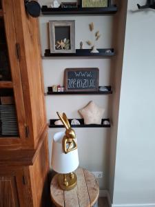 a lamp on a table in a room with shelves at B&B Zee-en-Zo Noordwijk in Noordwijk