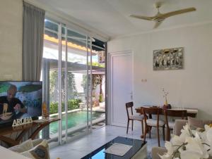 a living room with a dining room table and a large window at Aroha Villa in Banjar