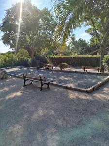 two park benches sitting in a park with trees at le victoire in Fréjus