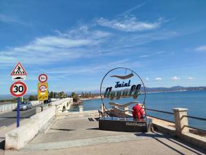 a man sitting on a bench next to the water at le victoire in Fréjus +6 photos