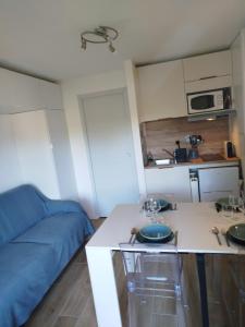 a small kitchen with a blue couch and a table at le victoire in Fréjus