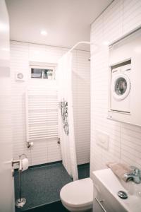 a white bathroom with a toilet and a sink at Casablanca Apartments in Keflavík