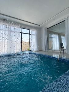 a large swimming pool with blue water in a room at شاليه غيوم الفندقية in Taif