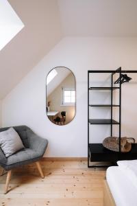 a living room with a chair and a mirror at SCHILCHERLANDLEBEN - Langegg in Greisdorf