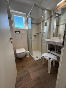 a bathroom with a shower and a toilet and a sink at Hotel Zur schönen Aussicht in Grömitz +74 photos
