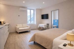 a hotel room with a bed and a chair and a table at Hôtel des Thermes in Bourbon-Lancy