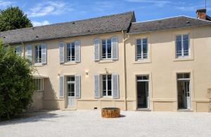 a large house with a barrel in front of it at Hôtel des Thermes in Bourbon-Lancy