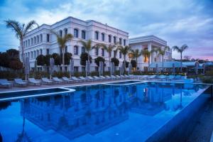 a hotel with a swimming pool in front of a building at Cunda Callisto Hotel & Spa Adult Only 12 in Ayvalık