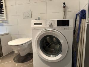 a bathroom with a washing machine and a toilet at Ferienwohnung Eichhorner in Außervillgraten