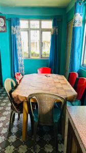 a dining room with a wooden table and chairs at NV Anjali Homestay in Sukhia Pokhari