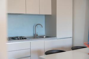 a kitchen with white cabinets and a sink at Regina e Oriente - La casa del Moro in Baveno