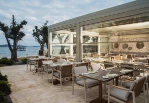 a restaurant with tables and chairs on a patio at Cunda Callisto Hotel & Spa Adult Only 12 in Ayvalık