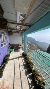 a porch of a house with a bench and flowers at NV Anjali Homestay in Sukhia Pokhari