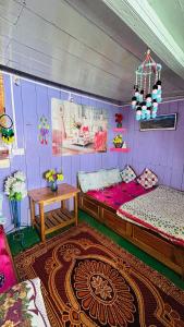 a room with two beds and a table in it at NV Anjali Homestay in Sukhia Pokhari