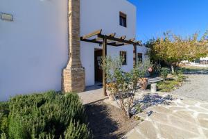 a white house with a brick pillar and a door at Villa Nastazia in Kiotari