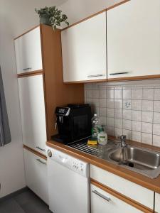 a small kitchen with a sink and a microwave at Ferienwohnung Eichhorner in Außervillgraten
