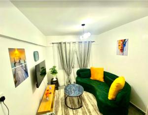a living room with a green couch and a table at Gated executive 1 bed in gated near Top Malls, Kisumu in Kisumu