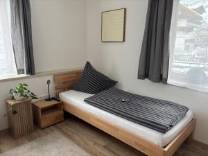 a bedroom with a bed with a black and white sheets at Ferienwohnung Eichhorner in Außervillgraten