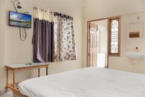 a bedroom with a bed and a television on the wall at HOTEL LS Residency in Salem