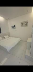 a white room with a bed and a chair at شاليه غيوم الفندقية in Taif +7 photos