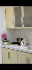 a kitchen with white cabinets and a sink and flowers at شاليه غيوم الفندقية in Taif
