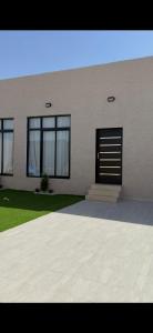 a building with a black door on the side of it at شاليه غيوم الفندقية in Taif