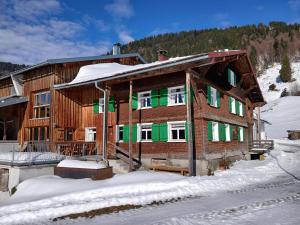a large wooden house with snow on the ground at Ferienhof Steurer in Balderschwang