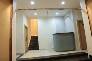 a living room with a tv in a room with stairs at Hotel Shiv Om in Ujjain