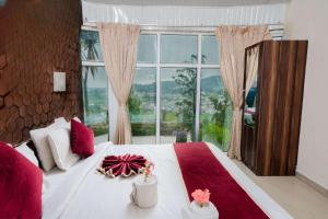 a bedroom with a bed with a large window at Tulips Resorts - Elkhill in Ooty