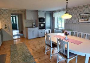 a kitchen and dining room with a table and chairs at Djup in Brevens Bruk