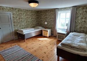 a bedroom with two beds and a window at Djup in Brevens Bruk