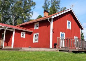 a red barn with a dog standing in front of it at Djup in Brevens Bruk